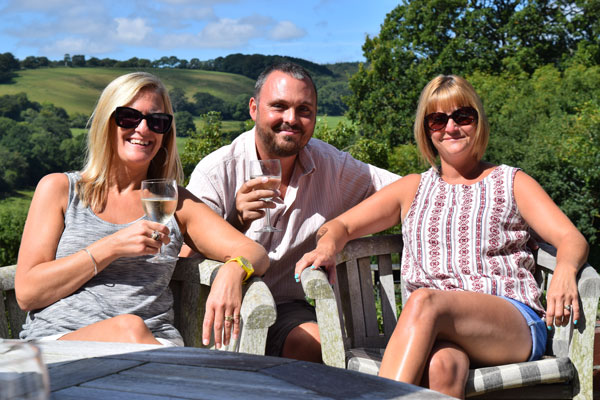 Three rather sunkissed looking people having a glass of bubbly in someones garden, splendid