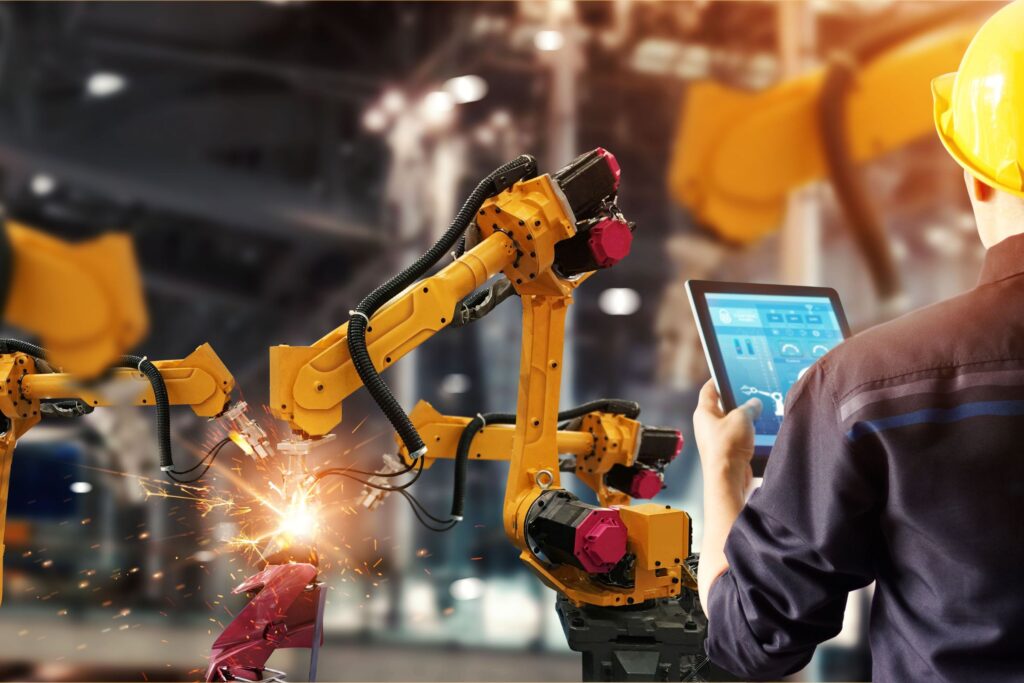 Engineer check and control welding robotics automatic arms machine in intelligent factory automotive industrial with monitoring system software. Digital manufacturing operation. Industry 4.0